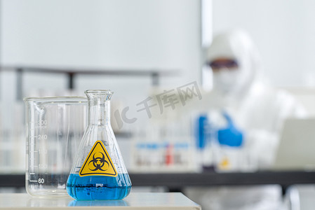 锥形烧瓶在白色实验室桌子上装有蓝色液体化学物质。