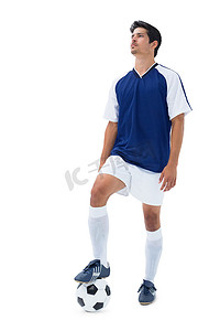 穿蓝色衣服的足球运动员拿着球站着