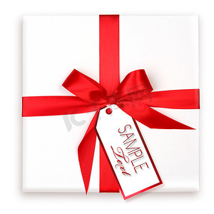 礼品装饰红丝带摄影照片_漂亮的包装节日礼物，带红丝带和礼品标签