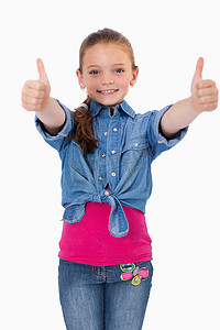 劳动节快乐字体摄影照片_一个快乐的女孩竖起大拇指的肖像