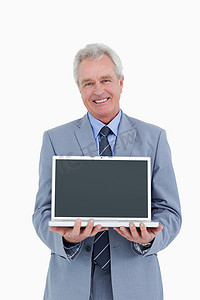 微笑的成熟商人展示笔记本电脑的屏幕