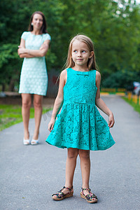 漫步摄影照片_年轻美丽母亲背景下时尚小女孩的特写