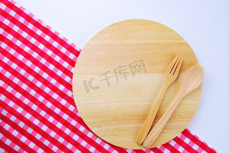 空木盘摄影照片_桌子背景上的木盘、桌布、勺子、叉子