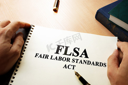 劳动合同摄影照片_办公桌上的《公平劳动标准法》(FLSA)。