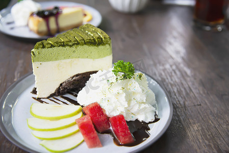 色彩缤纷的绿茶偏爱蛋糕，配有装饰精美的水果片和白盘中的生奶油 — 蛋糕食谱菜单概念
