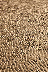 金色沙子金沙摄影照片_海滩沙子纹理波浪图案