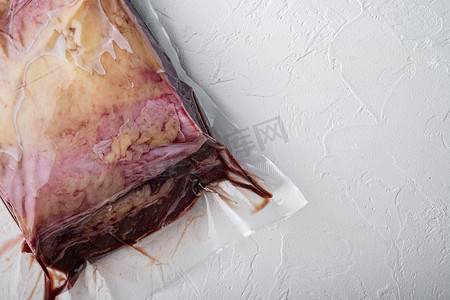 顶部沙朗牛肉用塑料包装切割，白色背景，顶视图，带有文本复制空间