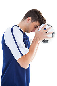 穿蓝色衣服的人摄影照片_穿蓝色衣服的足球运动员拿着球站着