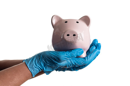 医生或护士戴着手术手套，拿着白色隔离的存钱罐。