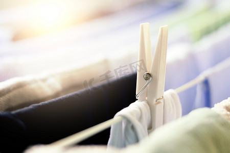 白色的衣夹将一件衣服挂在晾衣架上晾干