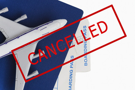 已取消摄影照片_飞机、护照和机票，上面有红色文字的印章，白色背景上已取消。