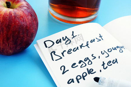 饮食计划摄影照片_一日饮食计划和苹果。