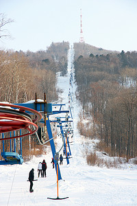 乘坐电梯摄影照片_滑雪者在山上乘坐缆车
