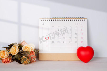 日历和花心形状，附有备忘录 2 月 14 日情人节在桌子上，提醒爱情惊喜、浪漫和甜蜜、庆祝和装饰、顶视图、节日概念。