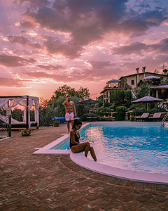 意大利带游泳池的豪华乡村别墅，意大利豪华别墅度假的情侣，男人和女人看日落