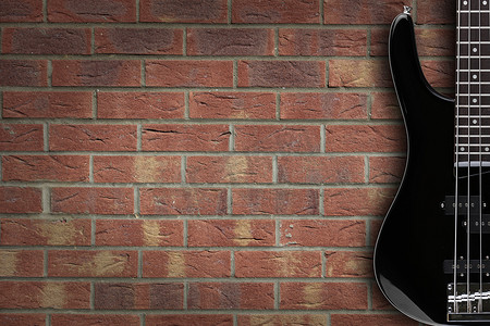 砖背景上的低音吉他与复制空间