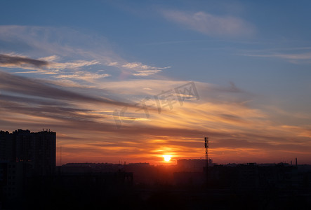红日mv摄影照片_红日的日落在城市上空的云层中。