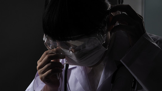 医生在夜间病房工作前佩戴防护面罩以预防冠状病毒