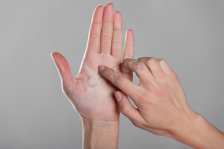 女性手指触摸张开的手。