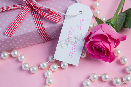 粉红玫瑰，带礼物、珍珠串和母亲节标签