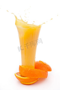 橘子皮包围着溢出的玻璃杯