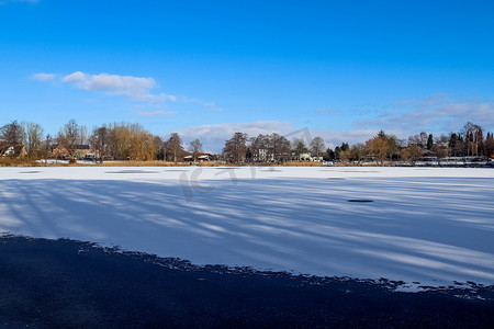 阳光明媚的日子里，北欧的冰雪覆盖了冰冻的湖面景观。