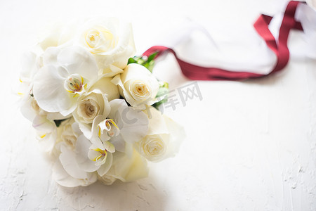 包装好的花摄影照片_白玫瑰和兰花的婚礼花束