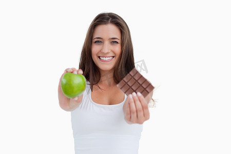 微笑的青苹果摄影照片_微笑的女人拿着一个青苹果和一块巧克力