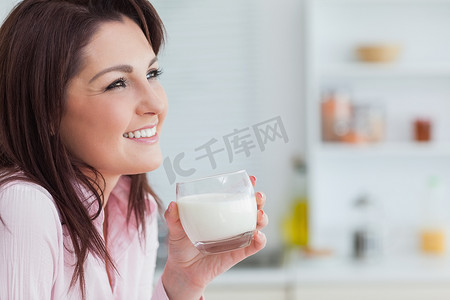 拿着一杯牛奶的女人的侧视图