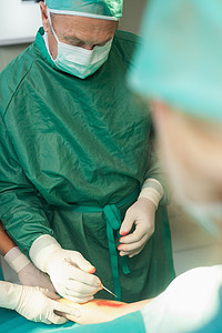 外科医生使用手术刀切割病人的皮肤