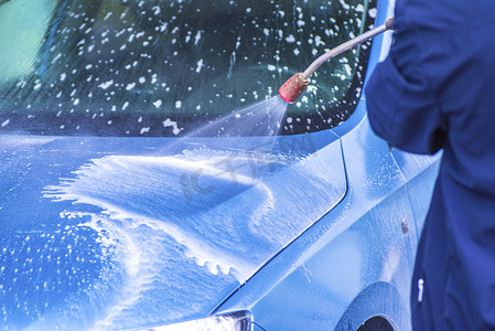 在室外洗车场用加压水手动洗车。使用高压水清洗汽车。