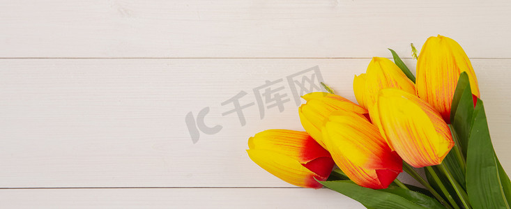 美丽的郁金香花在木质背景上，浪漫、母亲节或情人节，色调柔和，装饰自然，办公桌上的礼物花束，节日概念，横幅网站。