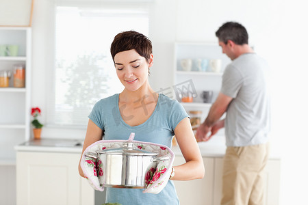 可爱的女人拿着锅，而男人正在洗碗