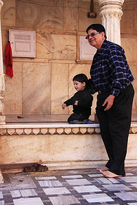德什诺克卡尼玛塔寺的一名男子带着一个小男孩在观察老鼠