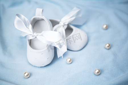 蓝色毯子上的白色婴儿靴
