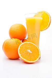 一杯橙汁附近的一堆橙子