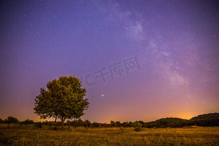 夜晚孤独摄影照片_夜晚和星星景观：夜晚清澈的银河，孤独的田野和树木