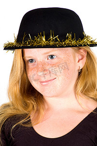 金色飘带摄影照片_女孩戴着一顶带有金色飘带的黑色帽子