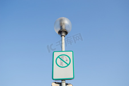 路灯上乱扔垃圾的街道上的警告标志