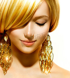 美丽的金发时尚模特女孩与金耳环