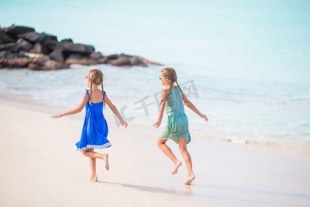 海滩小孩子摄影照片_快乐的小孩子在热带海滩一起玩耍，玩得很开心