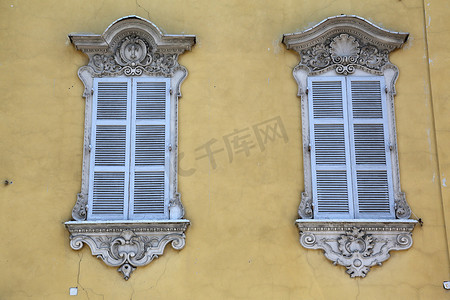 一栋古典房屋的窗户，采用典型的地区色彩“帕尔马黄”