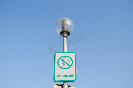 路灯上乱扔垃圾的街道上的警告标志