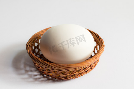 蛋黄摄影照片_鸡蛋在白色背景的篮子柳条中，鸭蛋在篮子里。