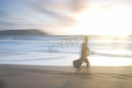 一个人拿着吉他走在海滩上。