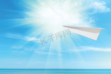 纸飞机映衬着蓝天和大海