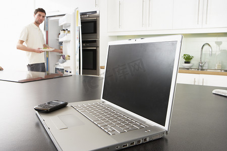现代厨房里的年轻人用笔记本电脑在厨房里修理小吃