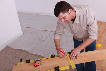 男子测量强化木地板的木板