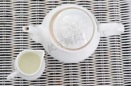 食物小茶壶摄影照片_带小牛奶罐的茶壶顶视图