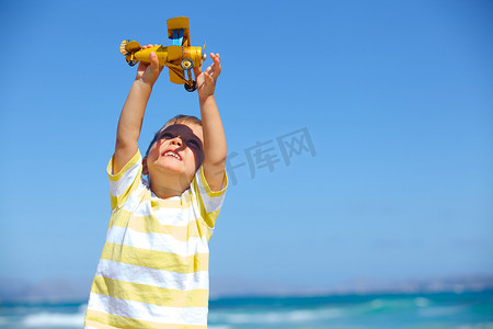 飞机大海摄影照片_男孩玩玩具飞机